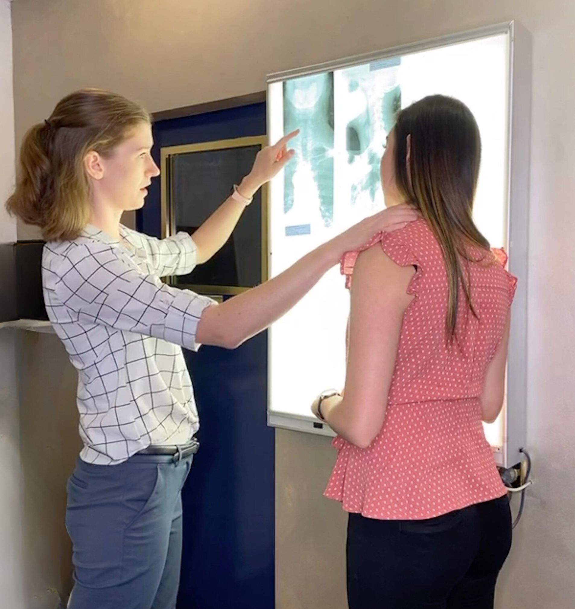 Dr Aimee Mason (Chiropractor) showing a patient her neck x-rays and explaining why this is the likely cause of her headaches